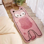 Tapis de sol moelleux et mignon représentant un chat rose stylisé avec des yeux souriants, placé dans un intérieur lumineux et cozy.