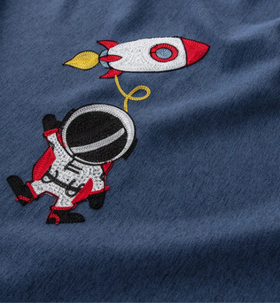 T-shirt pour enfants avec motif astronaute et fusée colorée, sur fond bleu. Style ludique et original idéal pour les jeunes passionnés d'espace et de découvertes interstellaires. Parfait pour apporter une touche de fantaisie à la garde-robe des petits aventuriers.