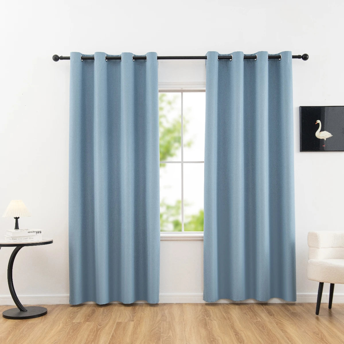 Rideaux occultants bleus pour salon moderne, installés sur une tringle noire au-dessus d'une fenêtre lumineuse. Accessoires décoratifs élégants pour un intérieur contemporain et apaisant.