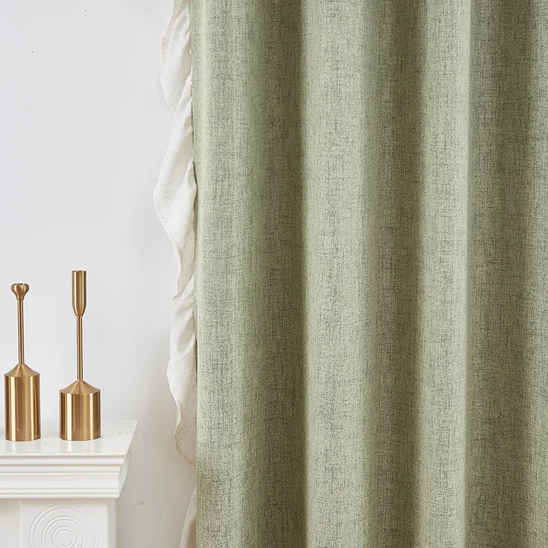 Rideau élégant de couleur vert clair pour décoration intérieure moderne, suspendu à côté d'accessoires décoratifs dorés sur une cheminée blanche. Idéal pour ajouter une touche de sophistication et de calme à n'importe quelle pièce.