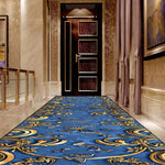 Couloir élégant avec moquette bleue ornée de motifs dorés sophistiqués.