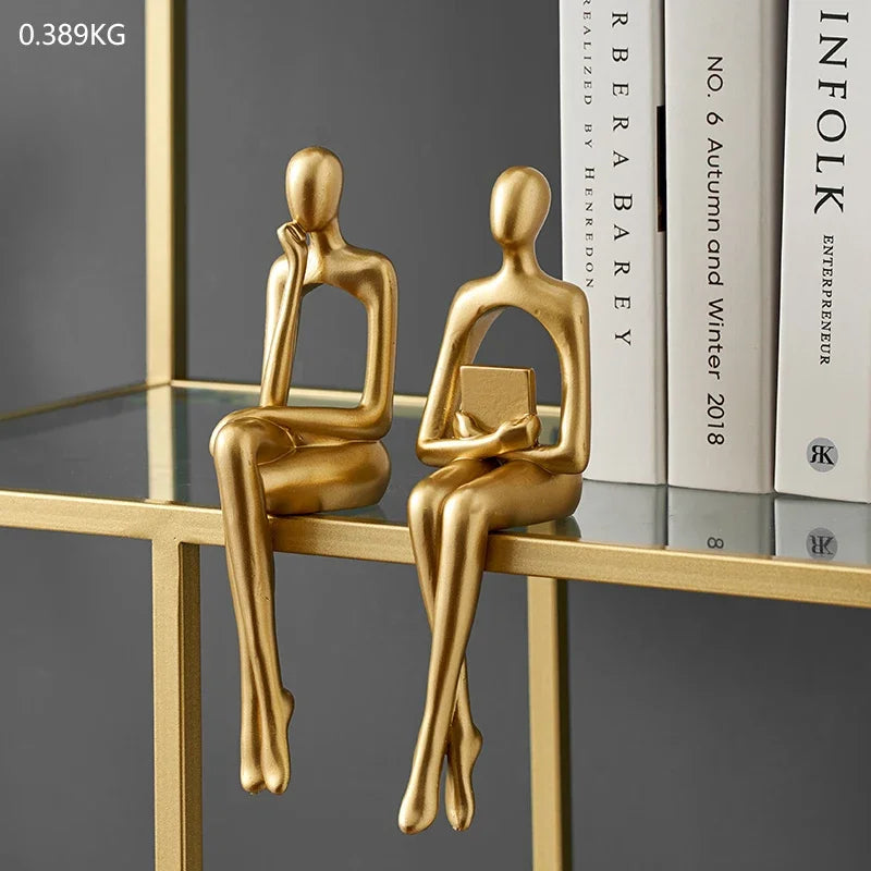 statues penseur dorées moderne décoration intérieure étagère salon lisse stylisée livre sphère verre architectural