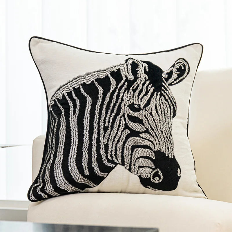 Un coussin orné d'un motif de zèbre en noir et blanc, avec des traits distinctifs et des formes graphiques, créant un élément décoratif élégant et moderne.
