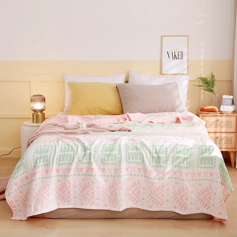 Lit douillet et accueillant avec une couverture motif géométrique pastel et un cadre décoratif sur le mur.