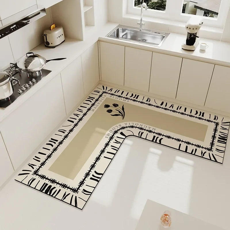 Un aménagement de cuisine moderne et épuré, avec des éléments graphiques en noir et blanc sur le carrelage au sol, créant une atmosphère élégante et design.