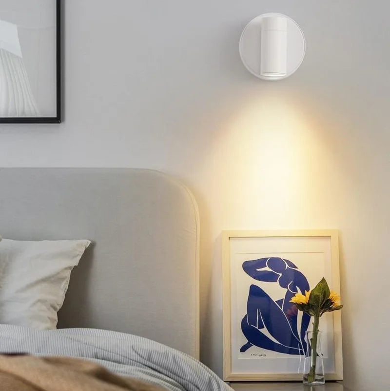 Lampe murale LED sans fil noire fixée au mur dans une chambre moderne