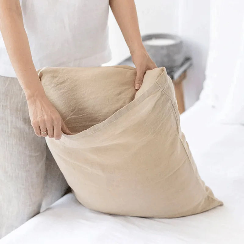Le sac beige montre une personne tenant un grand sac décontracté dans un environnement intérieur.