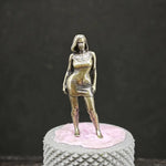 statue femme dorée moderne pose dynamique socle rose texture alvéolaire métallique brillante collection