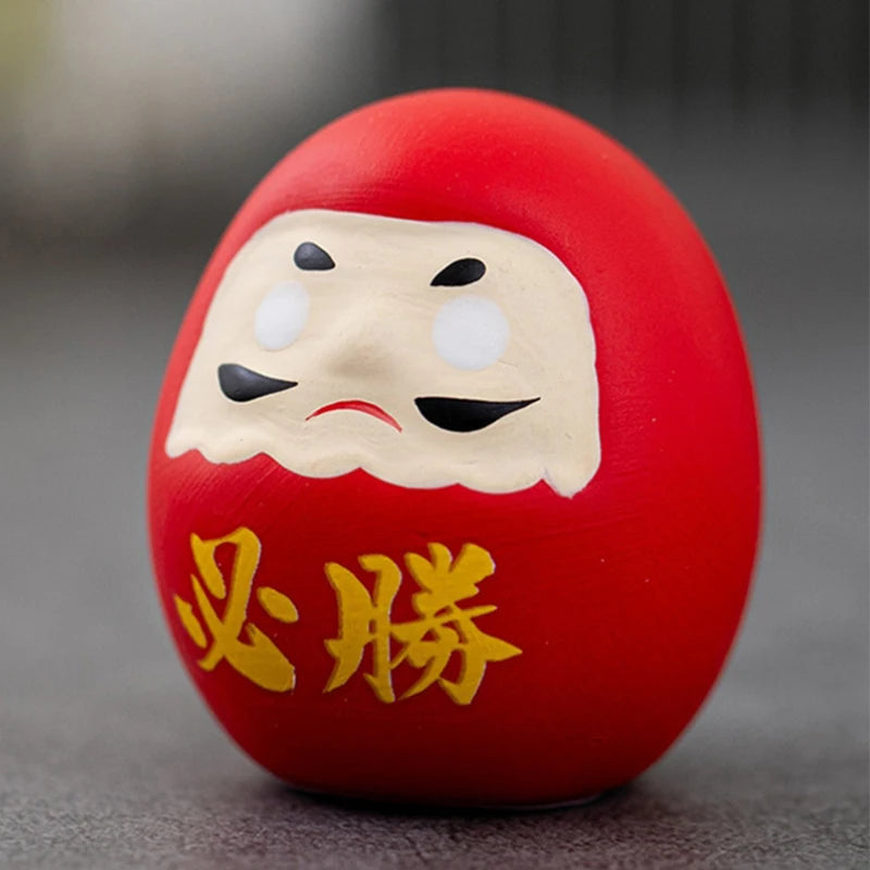 statuette japonaise daruma rouge or visage stylisé sourcils yeux barbe blanche traditionnelle décoration maisonporte