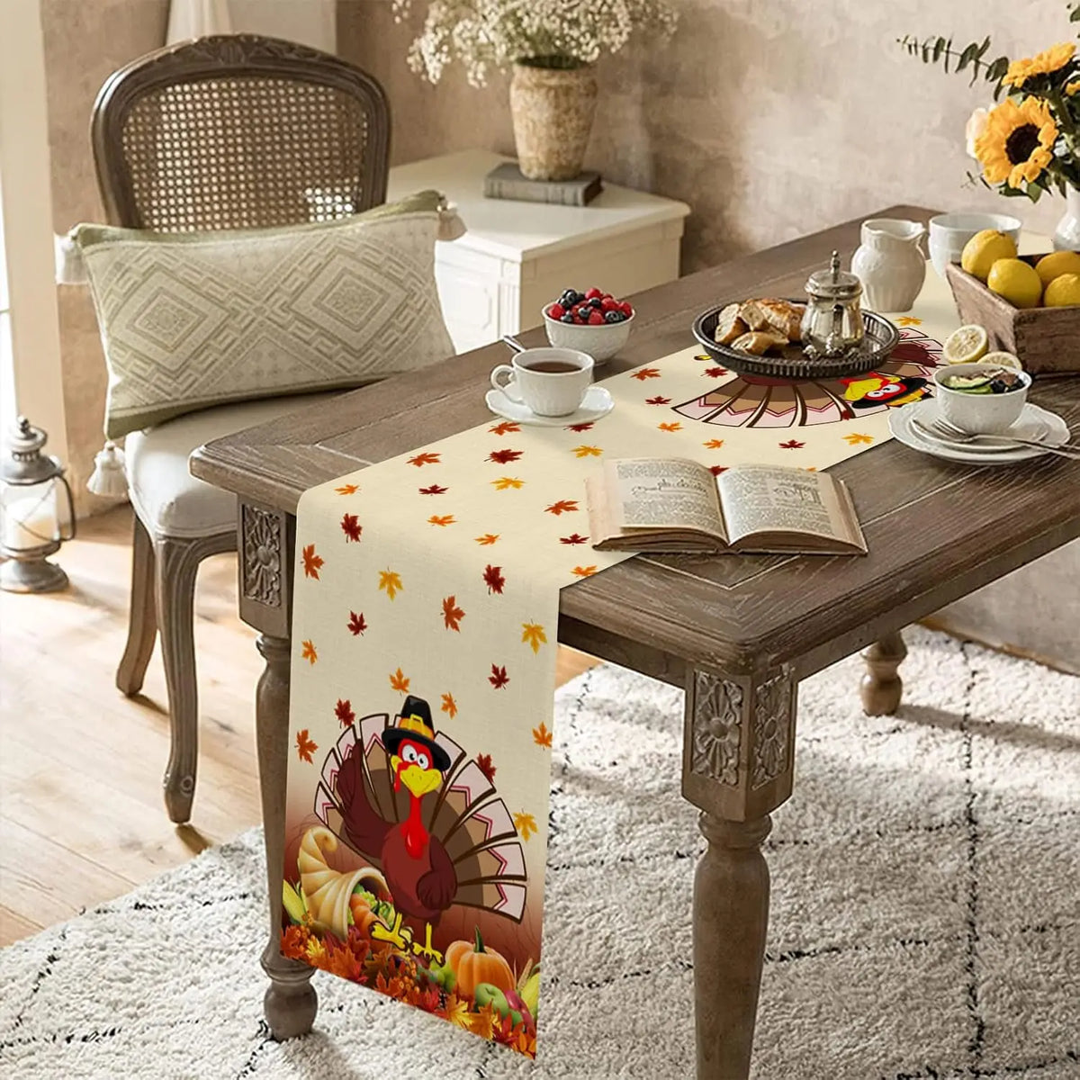 Une table de salle à manger décorée dans un style automnal, avec des plats, une tasse de thé et une courtepointe ornée de feuilles d'automne et d'un dindon, suggérant une ambiance chaleureuse et confortable.