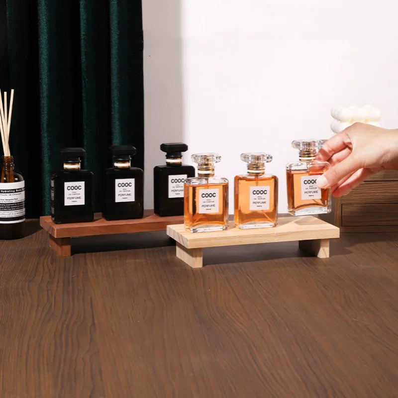 présentoir bois étagères parfum flacons transparents figurines décoratives diffuseur ambré rideau vert table festive