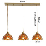 suspension lumineuse verre teinté art deco or marron bleu clair motifs géométriques opacité chaînes