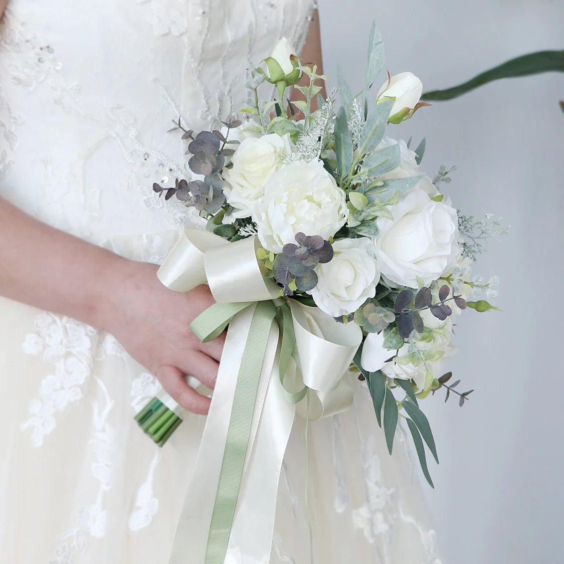 Bouquet de fleurs artificielles blanc ivoire dans un vase en verre sur une table