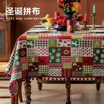 Nappe de table en patchwork colorée avec motifs de Noël, décorations florales et bougeoirs sur une table en bois.