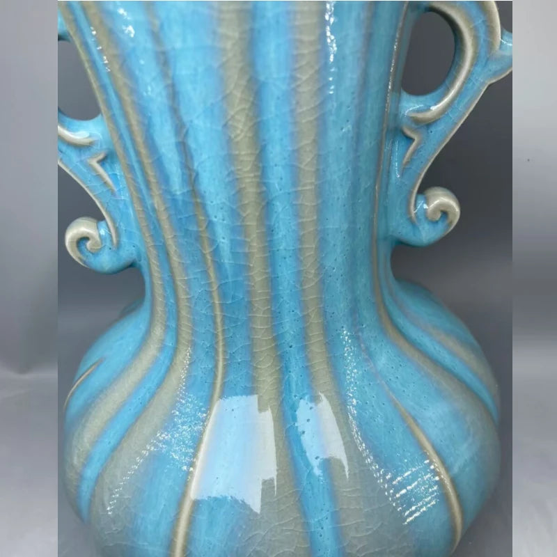 Cette image montre un vase en céramique bleu turquoise avec des motifs décoratifs élégants, offrant une texture et un design uniques.