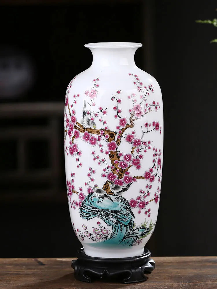 Un magnifique vase en porcelaine blanche décoré de fleurs de cerisier roses épanouies et d'un motif de paon sur un fond sombre, créant une scène élégante et raffinée.
