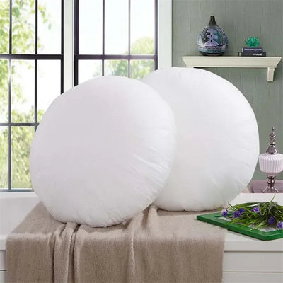 Coussin rond blanc en coton doux sur canapé gris