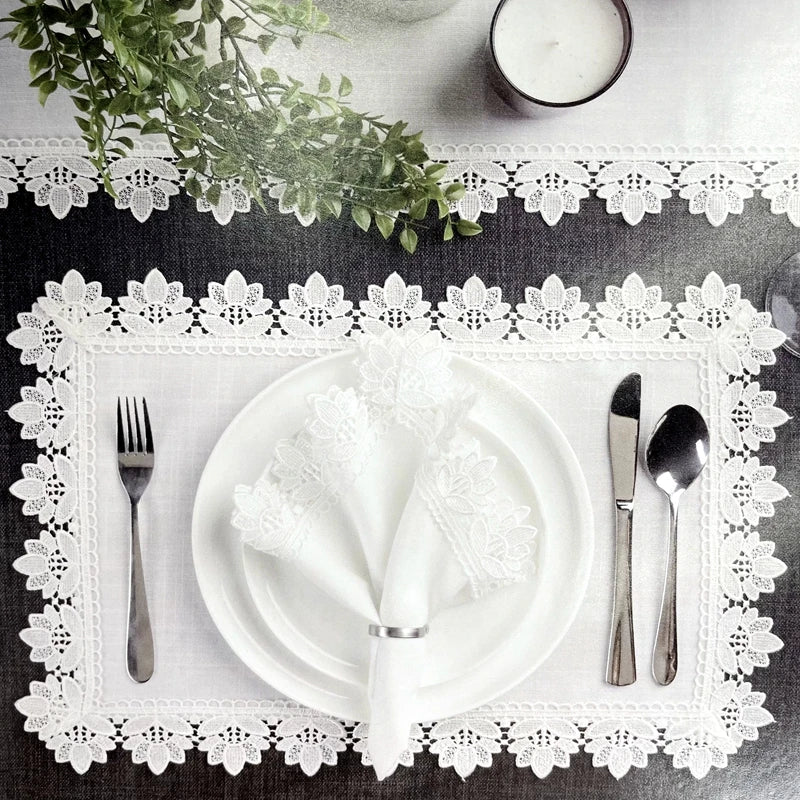 Une table élégante avec de la vaisselle blanche, des couverts en acier et de jolis éléments décoratifs.