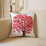 Un coussin décoratif arborant un arbre aux feuilles rouges vives, créant une atmosphère chaleureuse et automnale dans cette pièce.