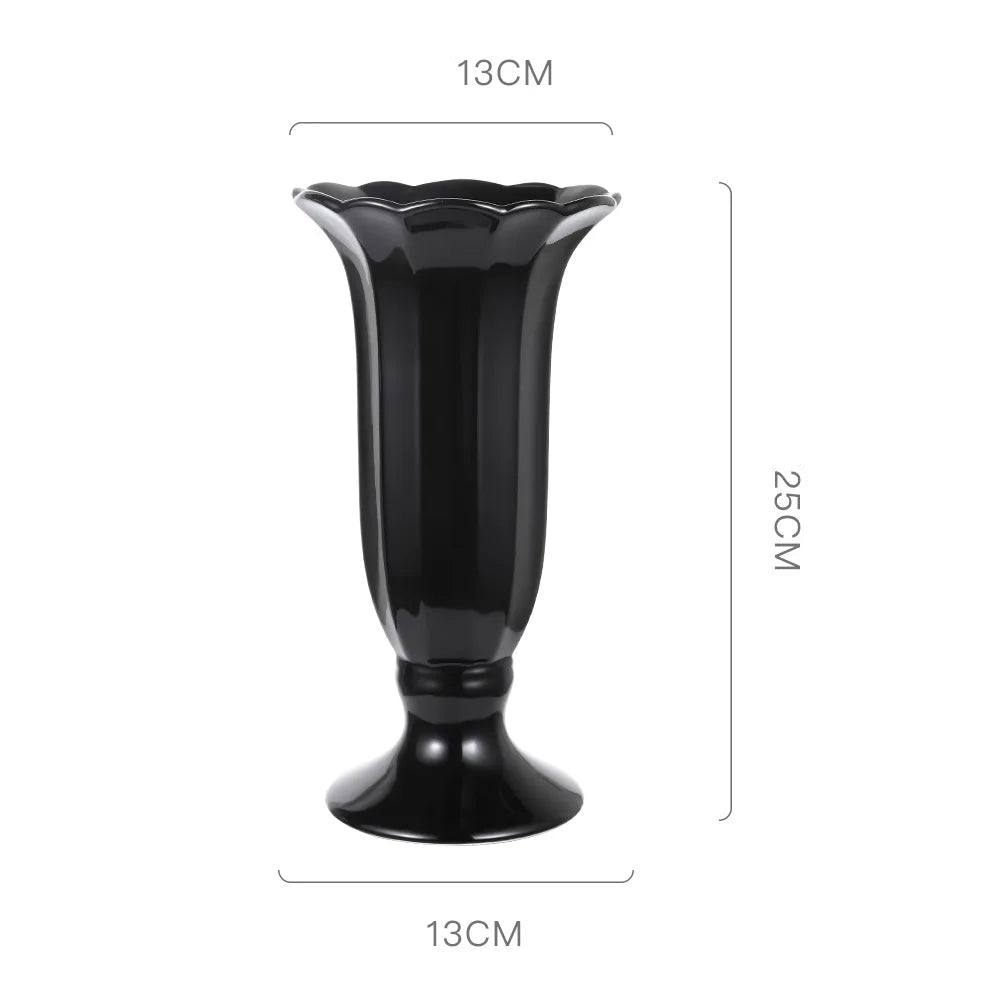 Vase en céramique noir lisse et élégant avec un design floral évasé.