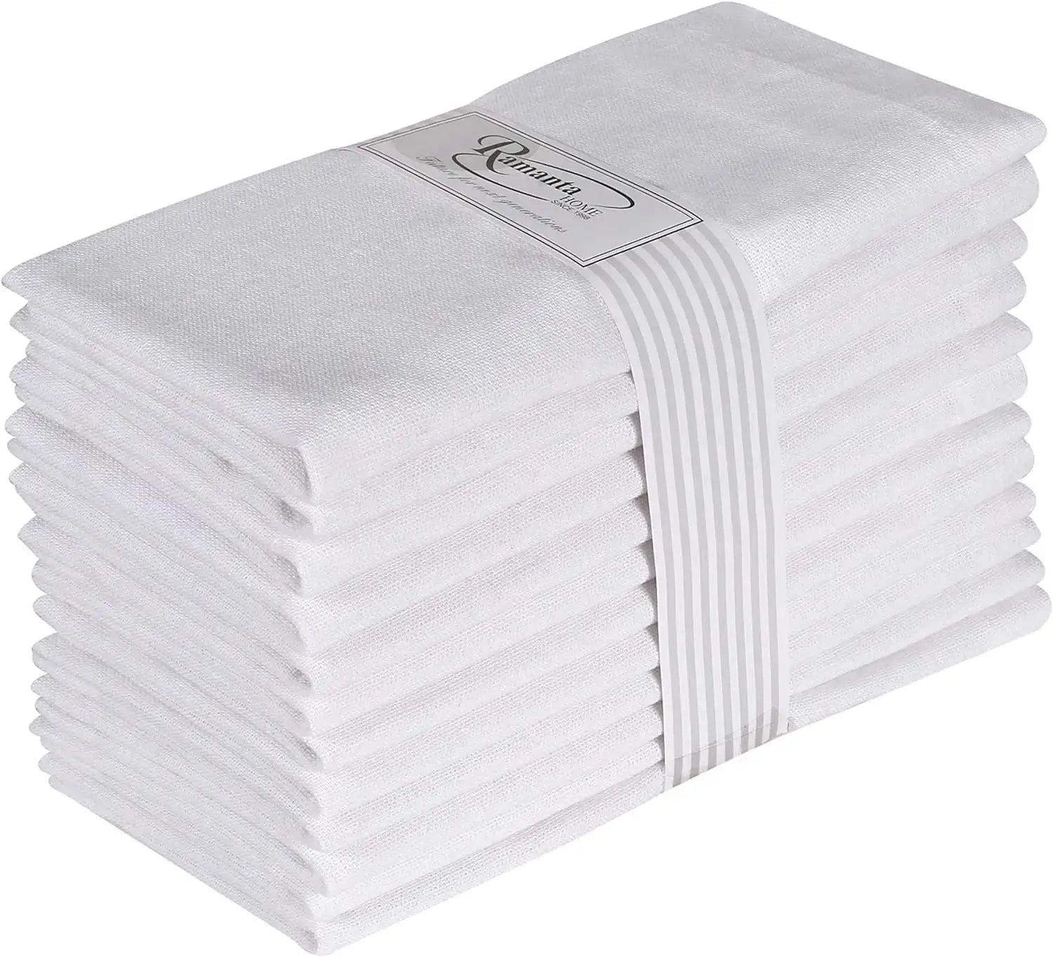 Une pile de serviettes de bain blanches et moelleuses, empaquetées avec un ruban blanc, prêtes à être utilisées.