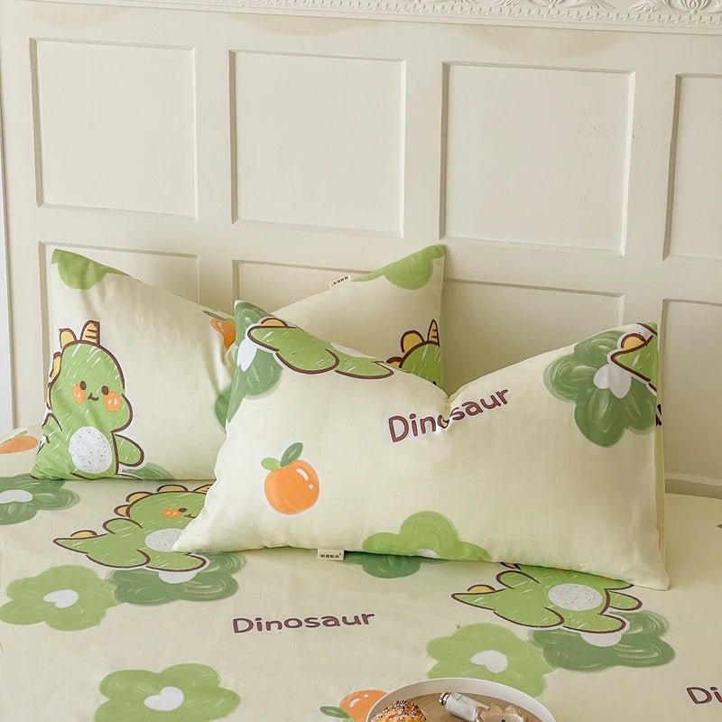 Draps de lit décoratifs pour enfants avec des motifs de dinosaures mignons et colorés sur un fond beige.