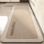 Cette image montre un tapis de sol gris avec le logo et le nom de la marque "Happiness" imprimés dessus.