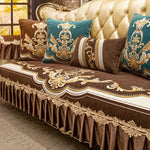 Canapé d'angle riche et orné de motifs dorés et bleu-vert, avec des coussins assortis, créant une ambiance luxueuse et chaleureuse.