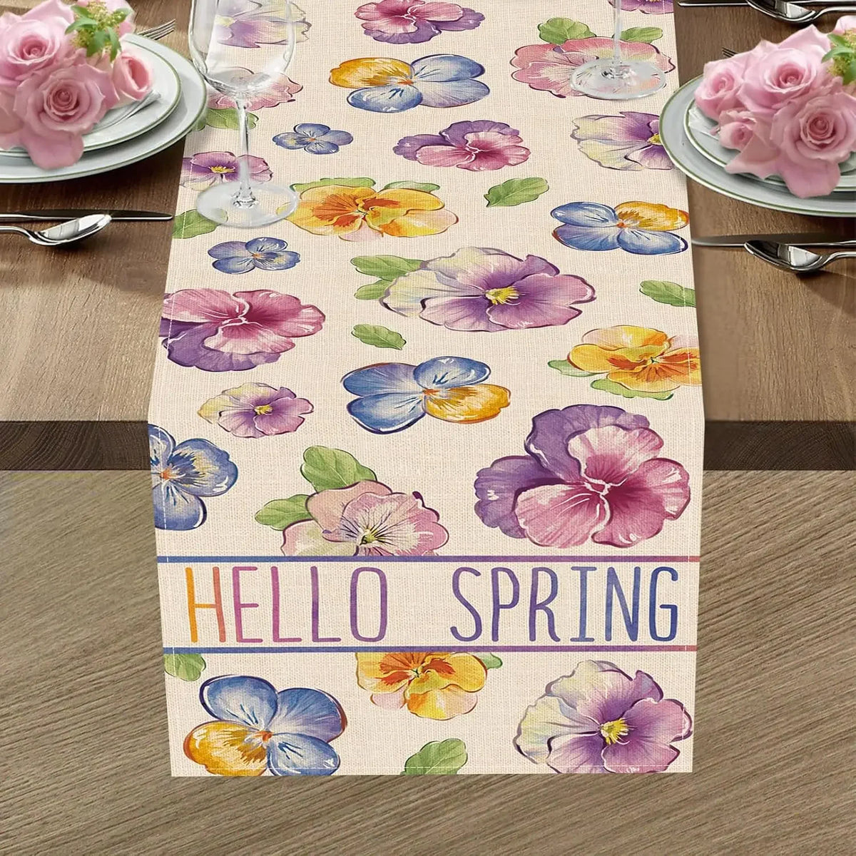 Chemin de table avec des fleurs colorées et l'inscription "Hello spring" indiquant l'arrivée du printemps.