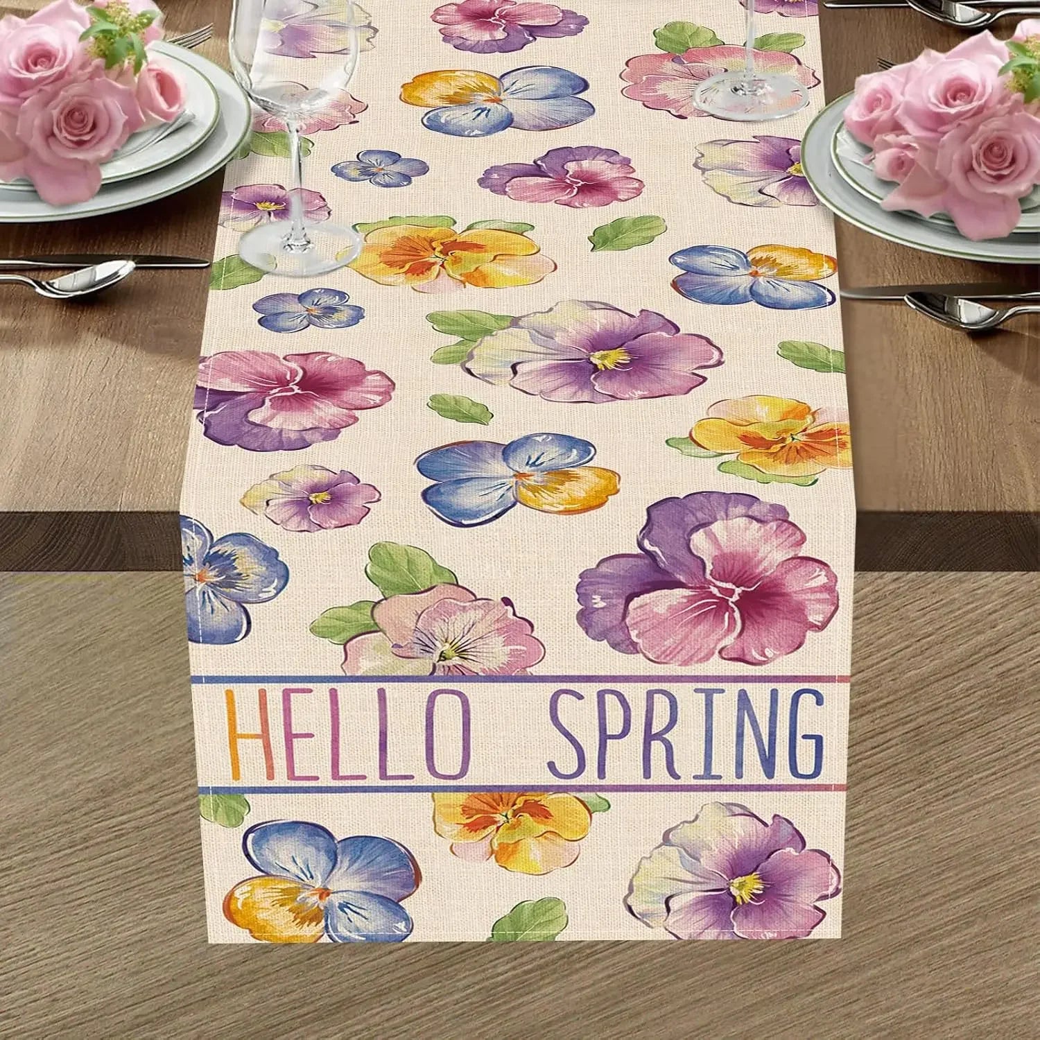 Chemin de table avec des fleurs colorées et l'inscription "Hello spring" indiquant l'arrivée du printemps.