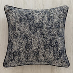 Coussin ornemental en tissu texturé noir et blanc, avec un motif abstrait qui ajoute de l'intérêt visuel.