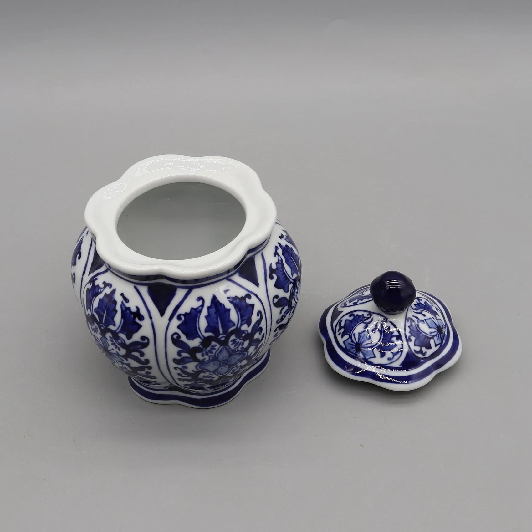 Un pot en céramique bleu et blanc avec un couvercle assorti, décoré de motifs floraux élégants.