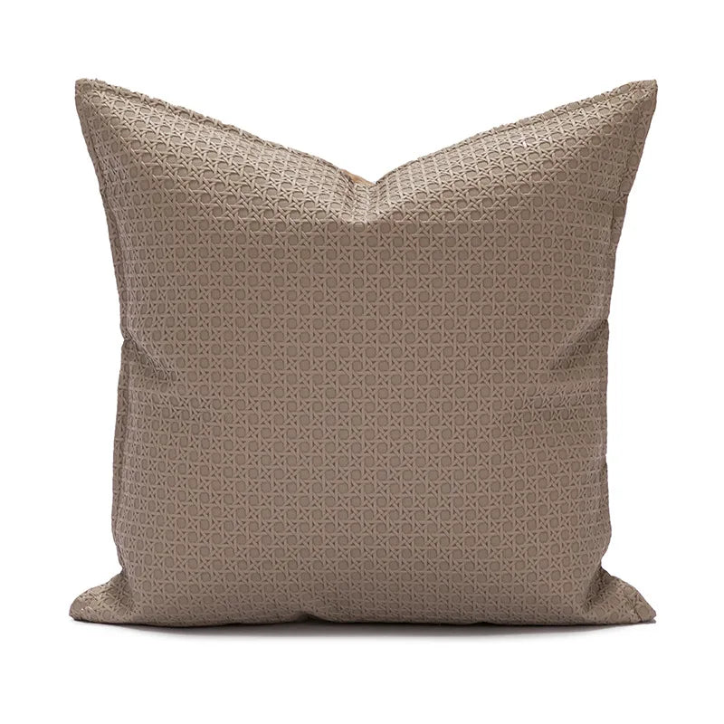 Coussin décoratif avec motif géométrique sur fond beige.