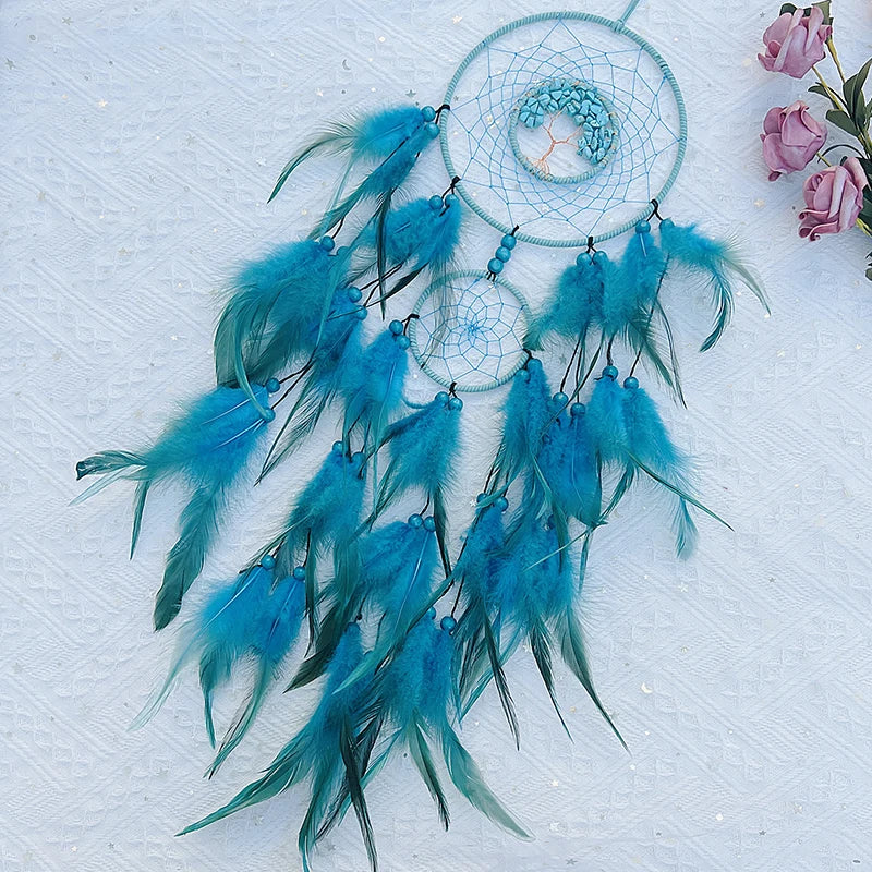 Captivant attrape-rêves bleu avec plumes turquoise et fleurs roses, suspendu sur fond glacé.