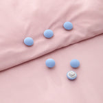 porte plaid peluche rose clair gris yeux fermés doux anti dérapant fixateur couette