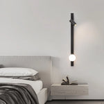 Paire de lampes murales dorées de chaque côté d'un lit moderne