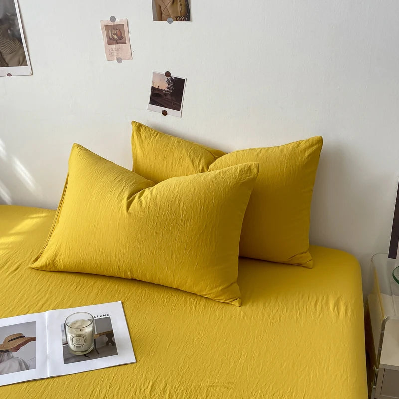 Ensemble de literie jaune vif, composé de draps et d'oreillers moelleux, créant une ambiance accueillante et chaleureuse dans la chambre.
