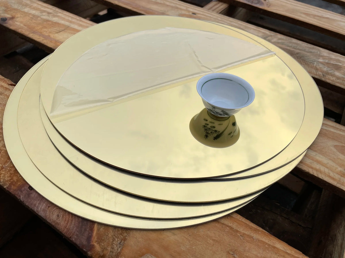 Miroir acrylique doré rond de 30cm sur table avec photo en dessous