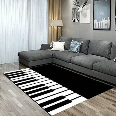 Un tapis noir et blanc représentant un clavier de piano occupe une grande partie du sol de cette pièce élégante, qui comprend également un canapé gris et des cadres muraux.