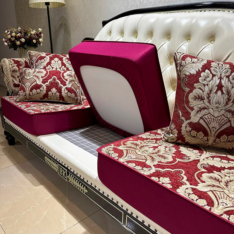 Élégant canapé capitonné et coussins décoratifs dans des tons rouge bordeaux et crème, créant une ambiance de luxe et de sophistication dans cette pièce.