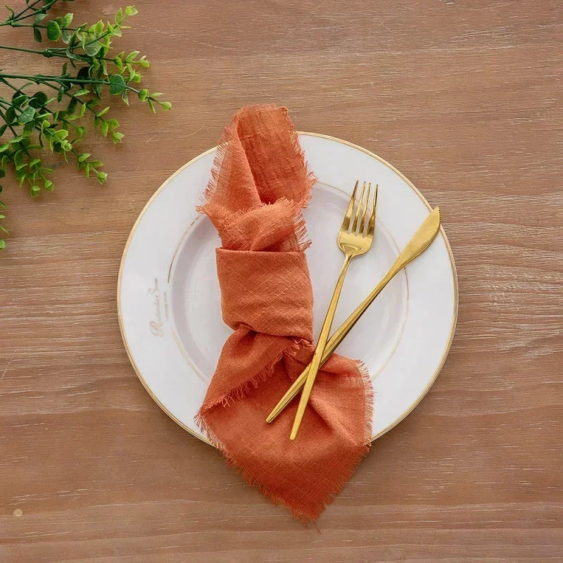 serviette table carrée orange franges moderne élégante fourchettes cuillères assiettesbranches séchées guirlande bougie parfumée
