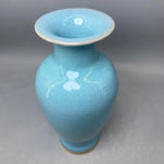 Vase en céramique bleu clair avec design de motifs en forme de cœur.