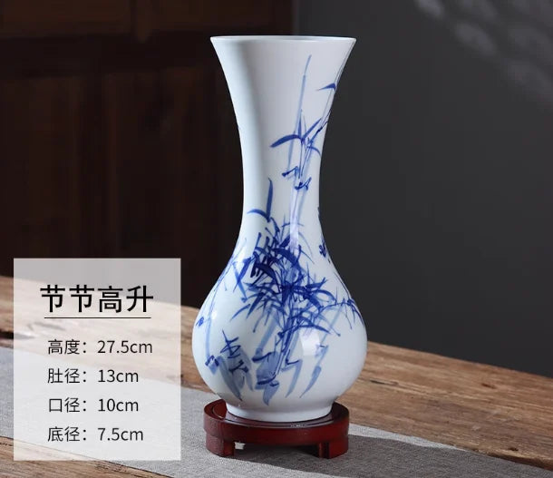 Vase céramique bleu et blanc avec motif de bambous, sur un socle en bois.