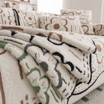 Une couverture douce et moelleuse avec un motif de fleurs marron et beige, idéale pour apporter de la chaleur et du confort dans la pièce.