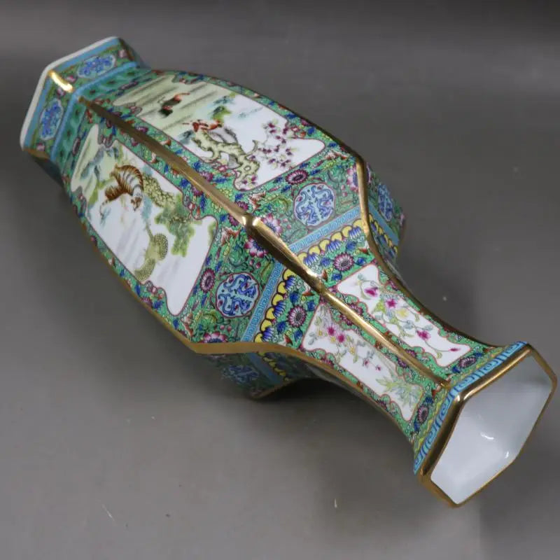 Un vase décoratif en porcelaine avec des motifs floraux et géométriques colorés, rehaussé de détails dorés, créant une pièce de collection raffinée.