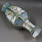 Un vase décoratif en porcelaine avec des motifs floraux et géométriques colorés, rehaussé de détails dorés, créant une pièce de collection raffinée.