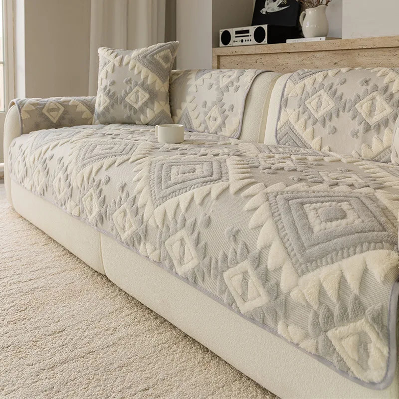 Canapé moelleux recouvert d'un couvre-lit matelassé décoré de motifs géométriques aux tons neutres, créant une atmosphère apaisante et élégante dans la pièce.