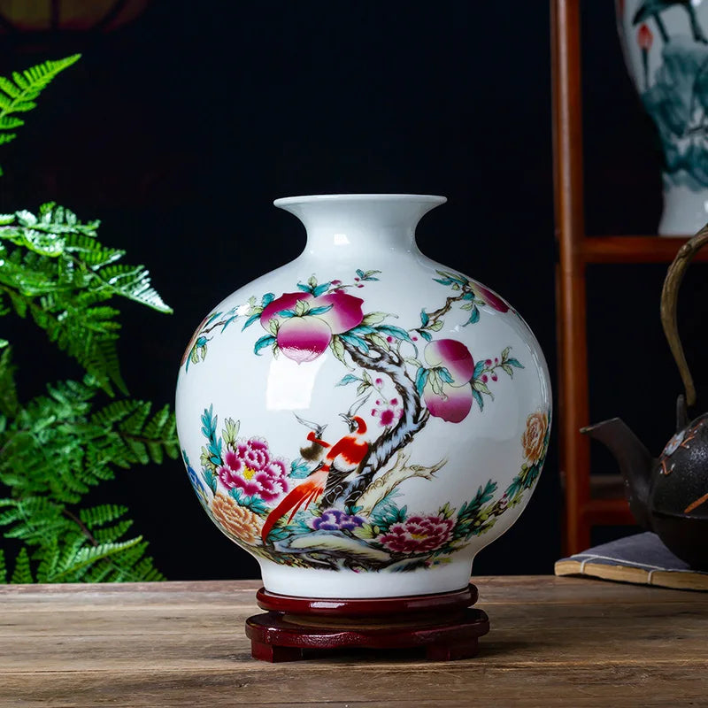 Un vase en porcelaine blanche décoré de peintures colorées de fleurs épanouies et d'oiseaux rouges, posé sur un socle en bois.