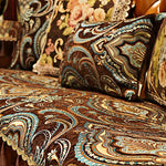 Motif de couleurs chaleureuses et de motifs ethniques complexes sur des coussins décoratifs.