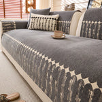 Un canapé gris confortable avec des coussins décoratifs et une tasse de café posée sur la table basse.